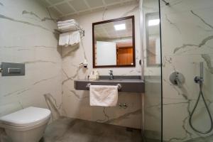 a bathroom with a toilet and a sink and a mirror at Belcehan Hotel in Oludeniz