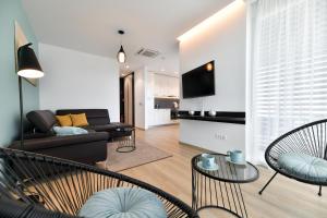 a living room with a couch and chairs and a tv at CROWONDER Apartments & Rooms OAZA with heated Swimming Pool and Sauna in Turanj