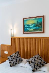 a bed with a wooden head board and a picture on the wall at Belcehan Hotel in Oludeniz