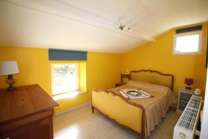 een slaapkamer met gele muren, een bed en een raam bij Chautardie 