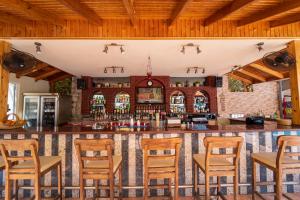 a bar in a restaurant with wooden chairs at Belcehan Hotel in Oludeniz