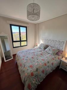 ein Schlafzimmer mit einem großen Bett und einem Fenster in der Unterkunft Apartamento Vistas Rovacias in Comillas