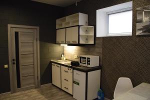 a small kitchen with white appliances and a window at Квартира лофт-стиль in Konotop