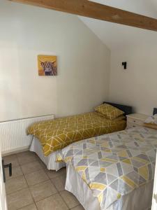 a bedroom with two beds and a painting on the wall at The Old Stables in Mews in Kessingland