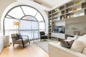 uma sala de estar com um sofá e cadeiras e uma janela em Covent Garden Luxury Retreat em Londres