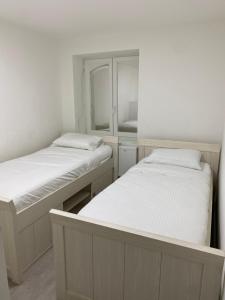 - 2 lits jumeaux dans une chambre avec miroir dans l'établissement Appartement Deux chambres près de Atomium, à Bruxelles