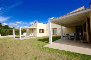 eine Terrasse mit Tisch und Stühlen in einem Hof in der Unterkunft Villa Franca by Wonderful Italy in San Teodoro