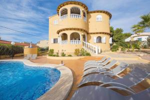 duży dom z basenem przed nim w obiekcie Villa Ortembach- PlusHolidays w mieście Calpe