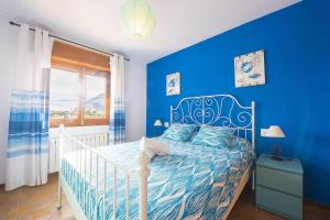 niebieska sypialnia z łóżkiem i niebieską ścianą w obiekcie Villa Ortembach- PlusHolidays w mieście Calpe +16 zdjęć