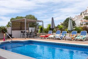 basen z krzesłami, parasolami i stołem w obiekcie Villa Miramar Burriana Beach 10 pax w mieście Nerja