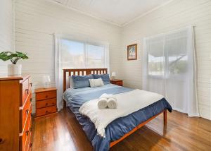 a bedroom with a bed with two towels on it at Driftway in Urunga