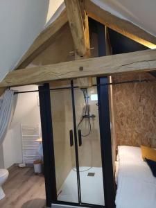 um quarto no sótão com uma cama e uma parede de vidro em AU BAIN Normand : bain nordique et détente. em Goderville