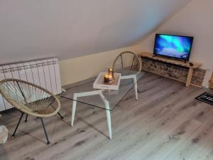 uma sala de estar com duas cadeiras e uma mesa com uma vela em AU BAIN Normand : bain nordique et détente. em Goderville