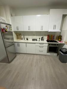 uma cozinha com armários brancos e um frigorífico em Appartement Deux chambres près de Atomium em Bruxelas