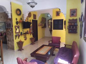 a living room with yellow walls and a table and chairs at Margueritte vacancy apartment in Casablanca