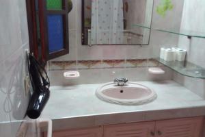 a bathroom with a sink and a phone on a counter at Margueritte vacancy apartment in Casablanca