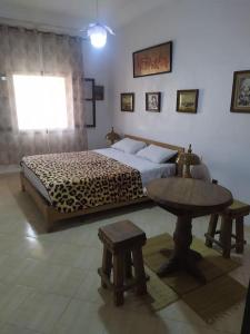 a bedroom with a bed and a table and a window at Margueritte vacancy apartment in Casablanca