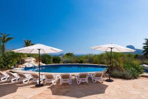 a swimming pool with chairs and umbrellas at Villa Paraiso - PlusHolidays in Benissa