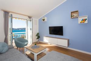 sala de estar con TV, sofá y mesa en Apartments Ana en Trogir