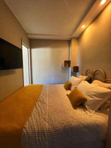 1 dormitorio con 1 cama blanca grande con almohadas amarillas en Les Roses by Welcome to Cannes en Cannes