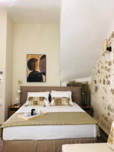 a bedroom with a king sized bed and a painting at Gaia Luxury Rooms in Rethymno Town