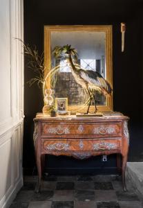 a bird standing on a dresser in front of a mirror at Chez Laurence Du Tilly in Caen