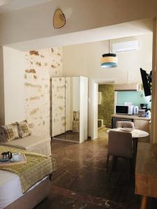 a living room with a couch and a table and a kitchen at Gaia Luxury Rooms in Rethymno Town