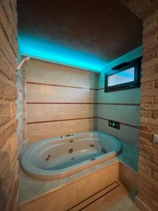 y baño con bañera y luz azul. en Colle Indaco Wine Resort & Spa, en Ortezzano
