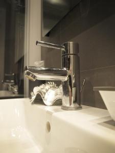 un lavandino in bagno con rubinetto cromato di La Cittadella a La Spezia Altre 16 foto