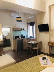 um quarto com uma cama e uma cozinha com uma mesa em Gaia Luxury Rooms em Rethymno Town