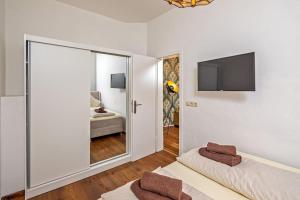 ein Schlafzimmer mit einem großen Spiegel und einem TV an der Wand in der Unterkunft Dresden Bakery Appartement in Dresden