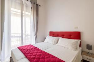 un letto con testiera rossa in una camera da letto di Mare e Monti a Scilla
