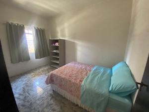 een kleine slaapkamer met een bed en een raam bij Apartamento Inteiro Central 2 Quartos e Kitnet Inteira 01 quarto in Ponta Grossa