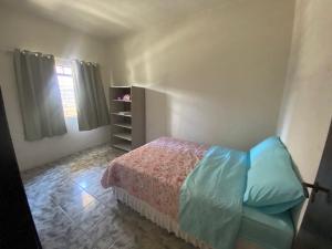 a small bedroom with a bed and a window at Apartamento Inteiro Central 2 Quartos e Kitnet Inteira 01 quarto in Ponta Grossa