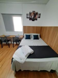 1 dormitorio con 1 cama grande con almohadas azules en Studio Liberdade Paulista DB2, en São Paulo