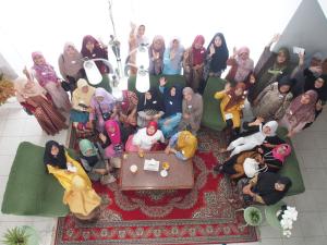 un grupo de personas posando para una foto en una habitación en Rumah Ijau - Halal Homestay, en Padangluar