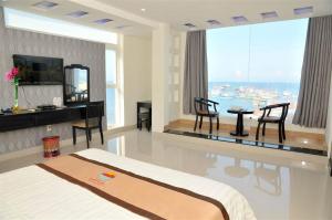 a bedroom with a bed and a table and chairs at Central Ly Son in Ly Son