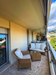 a balcony with a couch and chairs on a balcony at Les Roses by Welcome to Cannes in Cannes