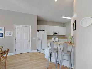una cucina con mobili bianchi, tavolo e sedie di Seahawk South C a Fort Morgan
