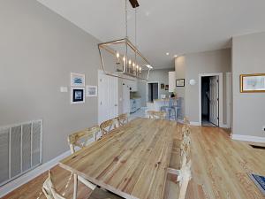 una sala da pranzo e una cucina con tavolo e sedie in legno di Seahawk South C a Fort Morgan