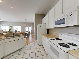 una cucina con armadi bianchi e un piano cottura bianco con forno di Seahawk South C a Fort Morgan Altre 86 foto