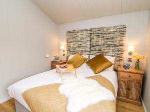 a bedroom with a bed with white sheets and a table at Fawns Rest in Rhayader