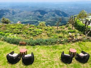 a group of chairs and stools on top of a hill at Kelburne Estate in Haputale