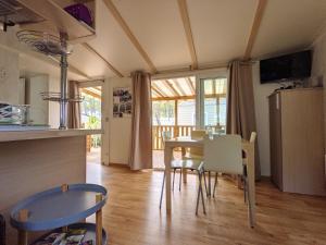 kuchnia i jadalnia ze stołem i krzesłami w obiekcie Bungalow chaleureux à Saint-Julien-en-Born avec piscine partagée w mieście Saint-Julien-en-Born