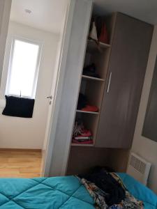 sypialnia z łóżkiem, oknem i szafą w obiekcie Bungalow chaleureux à Saint-Julien-en-Born avec piscine partagée w mieście Saint-Julien-en-Born