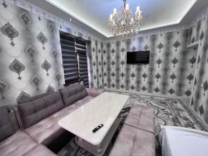 ein Wohnzimmer mit einem Sofa und einem Tisch in der Unterkunft COMFORT iNN 24 in Samarkand