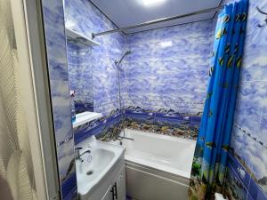 a blue tiled bathroom with a tub and a sink and a bath tub at COMFORT iNN 2 in Samarkand +14 photos
