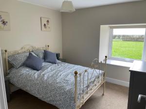 Un pat sau paturi într-o cameră la Teviot Cottage 7 Fenton Hill Farm