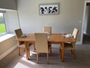 a dining room with a wooden table and chairs at Teviot Cottage 7 Fenton Hill Farm in Wooler +5 photos