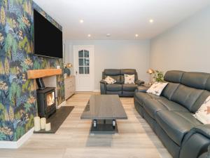 a living room with a couch and a fireplace at Artro in Cemaes Bay